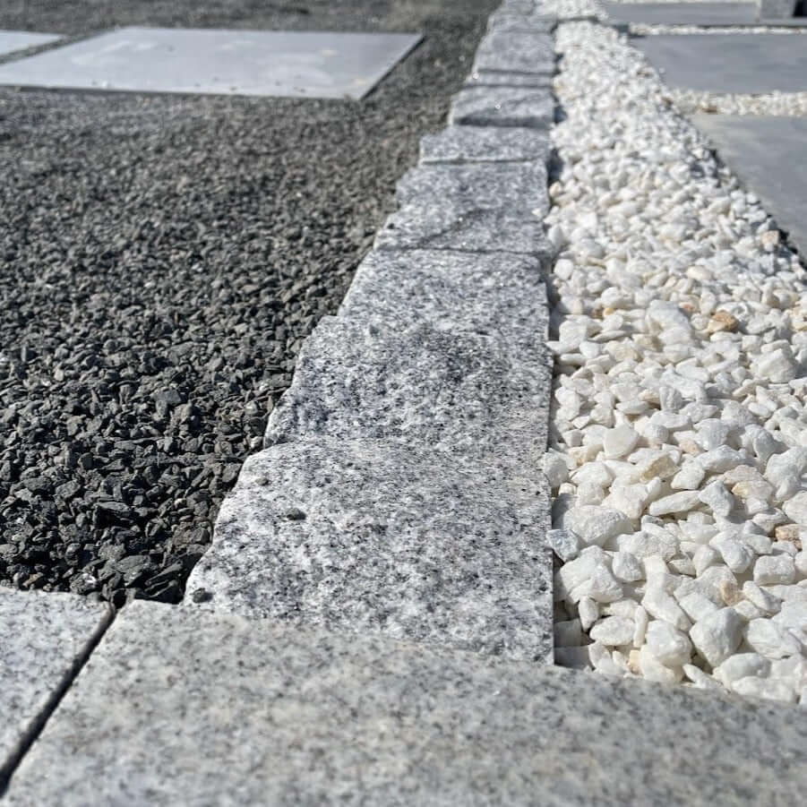 Adoquines de granito gris rústico ideales para jardinería y decoración de exteriores.