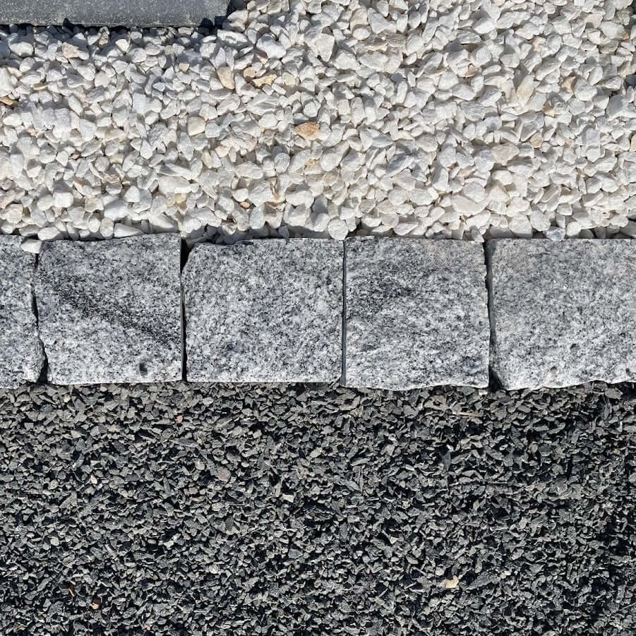 Adoquines de granito gris rústico ideales para pavimentar jardines y exteriores.