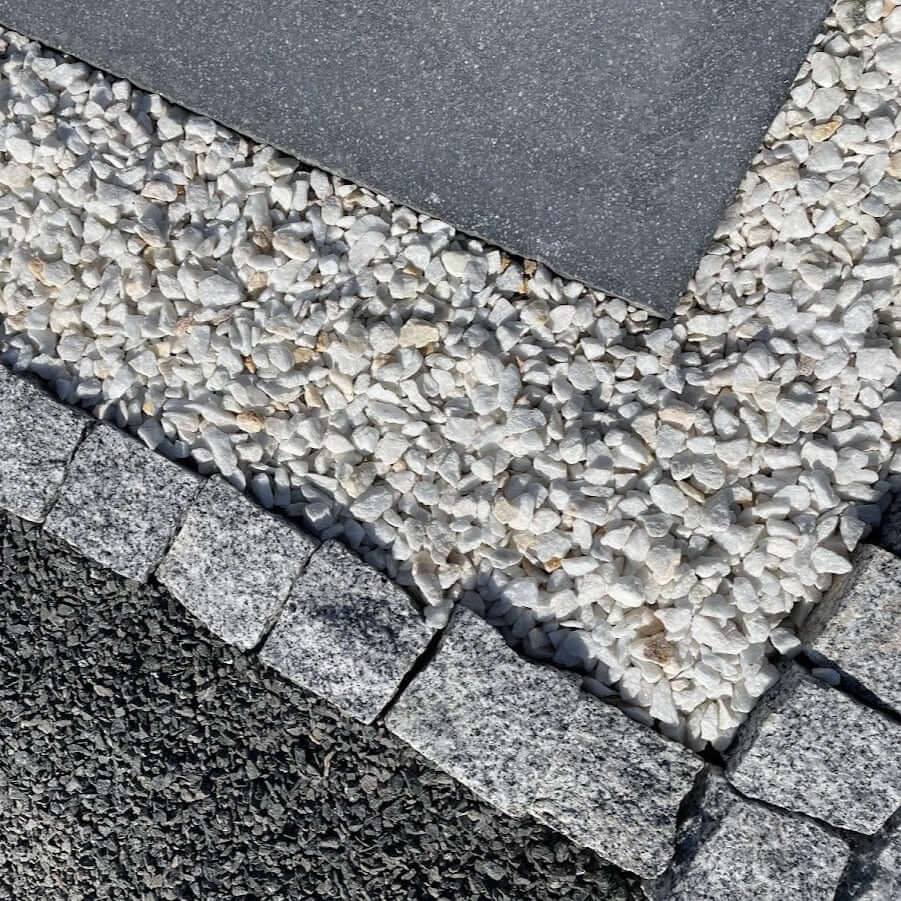 Adoquines de granito gris rústico ideales para pavimentación en jardines y exteriores.