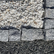 Adoquines de granito gris rústico ideales para jardines y caminos decorativos.