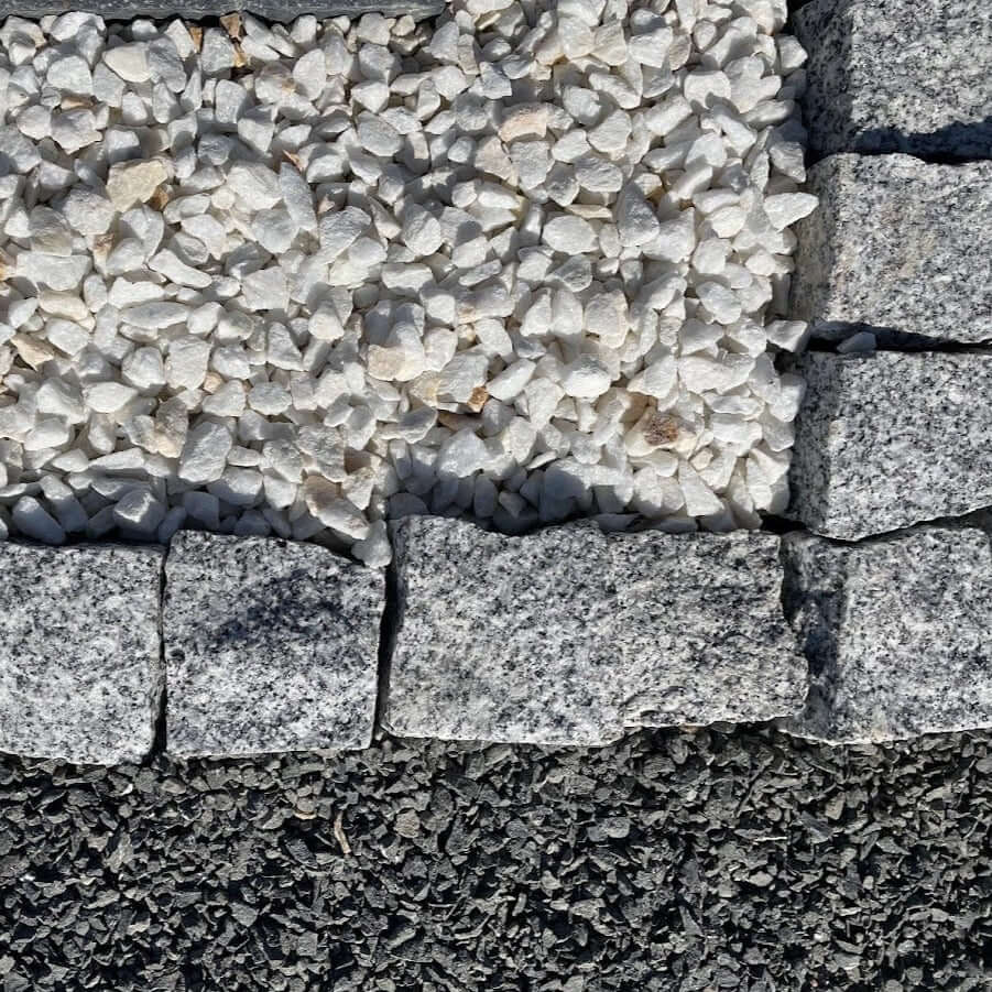 Adoquines de granito gris rústico ideales para jardines y caminos decorativos.