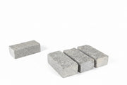 Adoquín de granito rústico ideal para jardines y caminos decorativos.