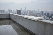 Cubremuros Ésera Doble Pendiente de hormigón, en el muro de un ático urbano bajo la lluvia - Vetonek
