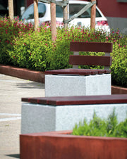 Bancos de hormigón gris y madera tropical Axis en un parque exterior, mostrando su integración perfecta en el paisaje urbano.