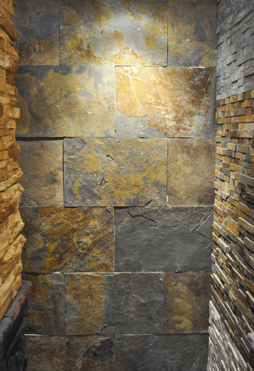 Pared interior revestida con pizarra natural Mendigorría en tonos grises y dorados